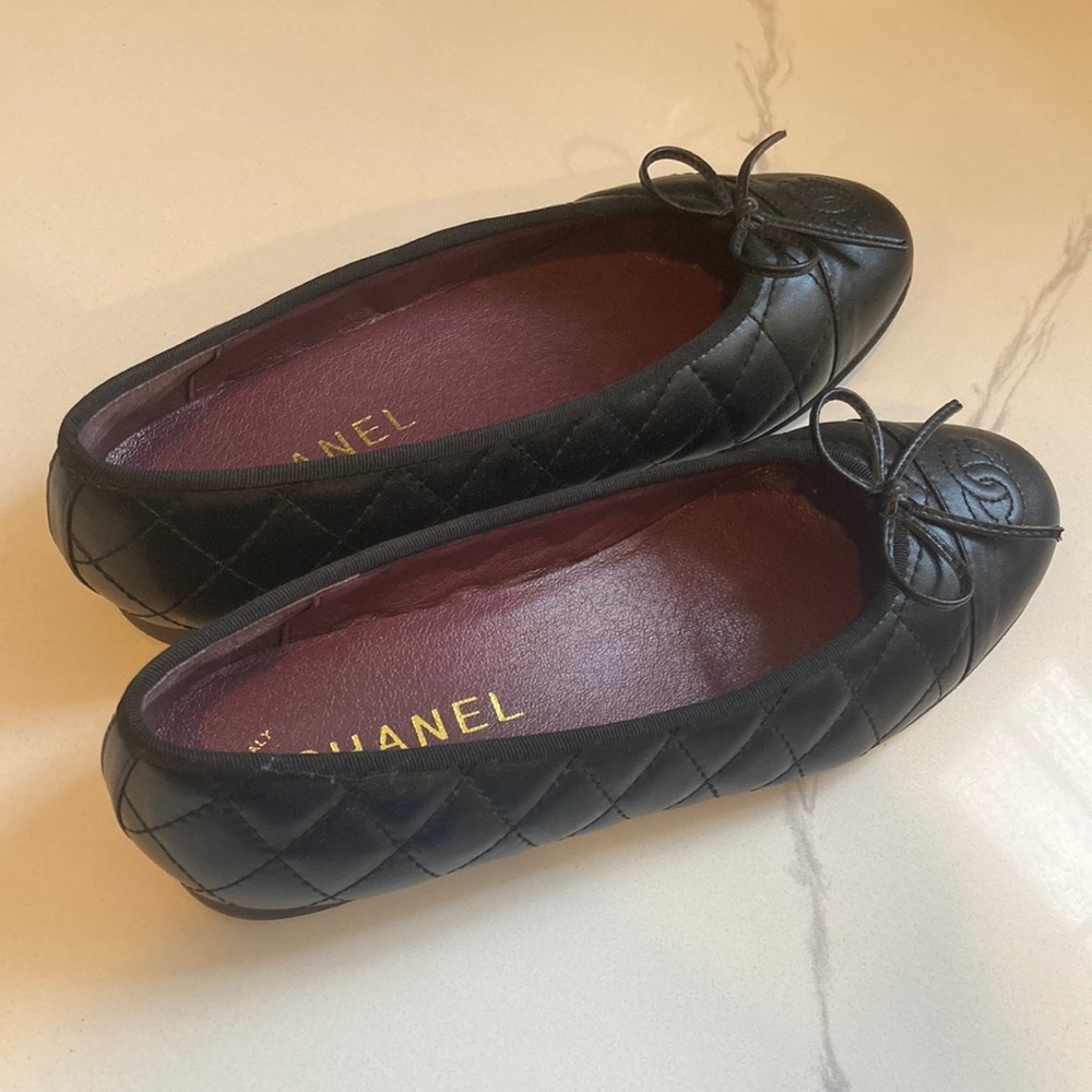 This is a Black and maroon Chanel ballerina flat. Found on the Chanel website